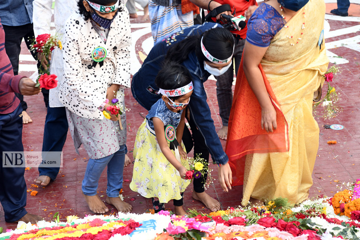 ভাষা শহিদদের প্রতি শ্রদ্ধা জানাতে ছোট মেয়েটি বাবা-মায়ের সঙ্গে কেন্দ্রীয় শহীদ মিনারে  এসেছে। ছবি: পিয়াস বিশ্বাস 