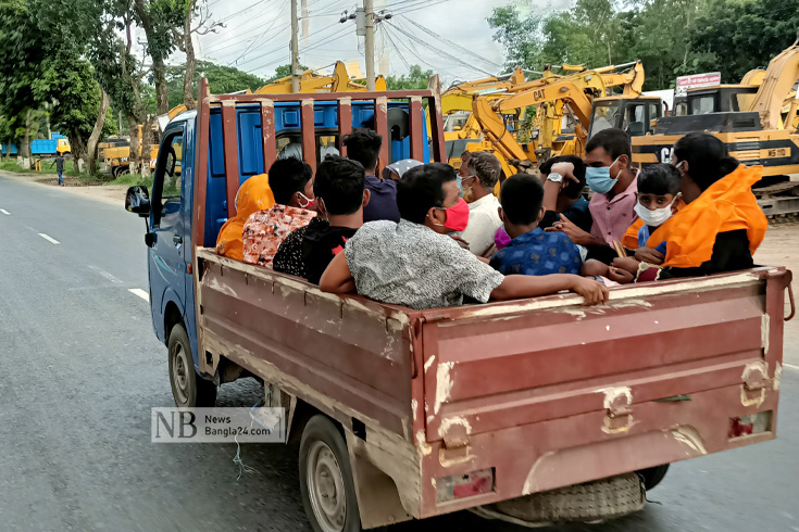 শাটডাউনে গণপরিবহন বন্ধ থাকায় পিকআপভ্যানে গাদাগাদি করে ঢাকায় ফিরছেন কর্মজীবী মানুষ। ছবিটি ঢাকা-আরিচা মহাসড়কের মানিকগঞ্জ সদরের মানড়া এলাকা থেকে তোলা। ছবি: আজিজুল হাকিম/নিউজবাংলা