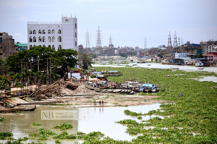 করোনাভাইরাসের কারণে লঞ্চ চলাচল দীর্ঘদিন ধরে বন্ধ। যার কারণে নদী কচুরিপানায় ভরে যাওয়ায় ছোট ছোট খেয়া পারাপারে সমস্যা হচ্ছে। ছবিটি বুড়ীগঙ্গা নদী থেকে তুলেছেন সাইফুল ইসলাম/নিউজবাংলা