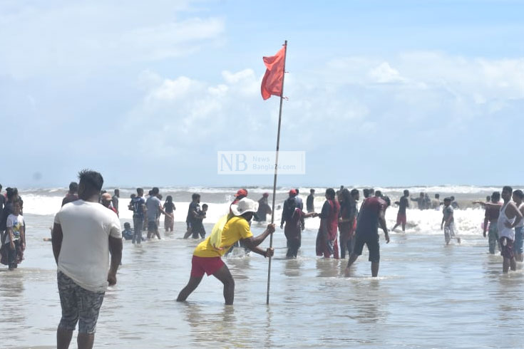 দীর্ঘদিন পর পর্যটনকেন্দ্র খুলে দেয়ায় কক্সবাজার সমুদ্রসৈকতে ভিড় করছেন পর্যটকরা। সৈকতে ৩ নম্বর বিপদ সংকেত থাকায় লাল পতাকা দেখিয়ে তাদের সতর্ক করা হচ্ছে। ছবি: সাইফুল ইসলাম