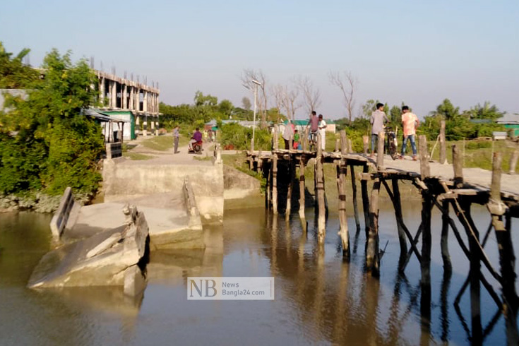 নোয়াখালীর হাতিয়া উপজেলার নিঝুমদ্বীপ ইউনিয়নের ছোয়াখালী মোল্লা গ্রামের নিঝুমদ্বীপ জাতীয় উদ্যানের প্রধান সড়কের ব্রিজটি ভেঙে খালে পড়ে গেছে। এতে অস্থায়ীভাবে নির্মিত কাঠের সাঁকোতে ঝুঁকি নিয়ে চলাচল করছেন পর্যটক ও স্থানীয় বাসিন্দারা। ছবি: মোহাম্মদ সোহেল/নিউজবাংলা