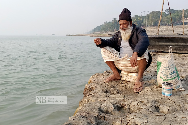 শখের বসে পড়ন্ত বিকেলে বড়শি দিয়ে পদ্মায় মাছ শিকার করছেন একজন বয়স্ক মানুষ। ছবিটি মানিকগঞ্জের শিবালয় উপজেলার অন্বয়পুর এলাকা থেকে তোলা। ছবি: আজিজুল হাকিম/নিউজবাংলা