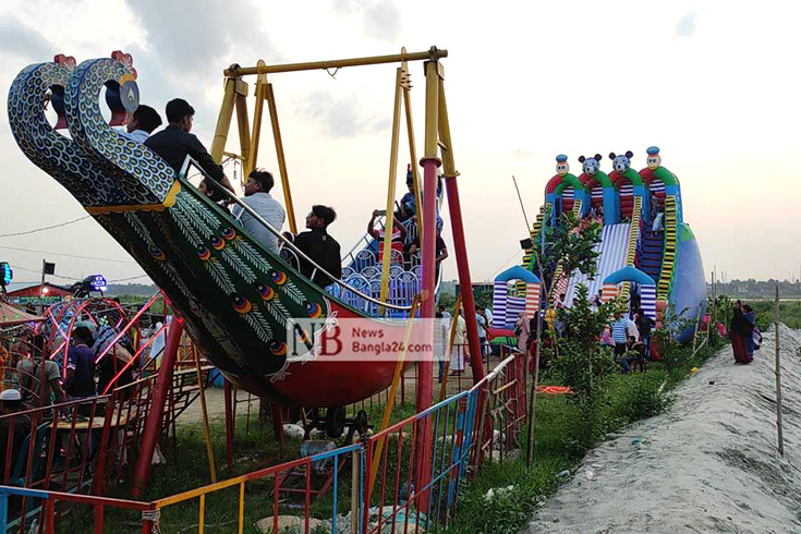 নরসিংদী সদরের নজরপুর ইউনিয়নের বুদিয়ামাড়ায় গড়ে উঠেছে অস্থায়ী এই বিনোদন পার্ক। পার্কে প্রাণবন্ত বিস্তীর্ণ চরাঞ্চল। খোলা আকাশের নিচে সাজানো নানা রাইডস। তাতে শিশুদের পাশাপাশি চড়ছেন বড়রাও। খাবারের দোকান, হরেক পণ্যের ছোটখাটো স্টলে জমজমাট পার্কটি। ছবি: খন্দকার শাহীন/নিউজবাংলা