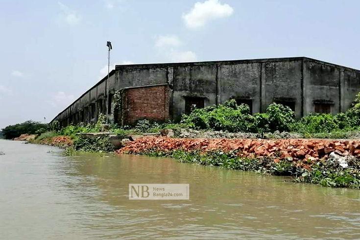 গোপালগঞ্জের টুঙ্গিপাড়া উপজেলার গওহরডাঙ্গা গ্রামে মধুমতী নদীর তীব্র ভাঙনের মুখে পড়েছে উপজেলার একমাত্র পাটকলটি। ভাঙন ঠেকাতে কর্তৃপক্ষ খোয়া, ইট ও বস্তা ফেললেও এতে কোনো কাজ হচ্ছে না। ওই পাটকলের ভবন থেকে মাত্র দুই থেকে তিন ফুট দূরেই অবস্থান করছে মধুমতী। ছবি:  মোজাম্মেল হোসেন মুন্না/নিউজবাংলা