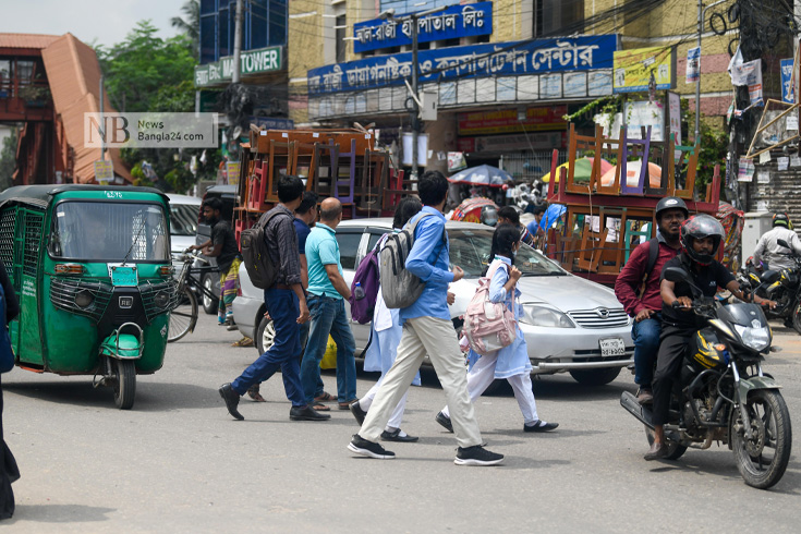 পাশেই ওভারব্রিজ, তবু ট্রাফিক আইন অমান্য করে ঝুঁকি নিয়ে রাস্তা পারাপার হচ্ছে পথচারীরা। ছবিটি ফার্মগেট এলাকা থেকে তোলা। ছবি: পিয়াস বিশ্বাস