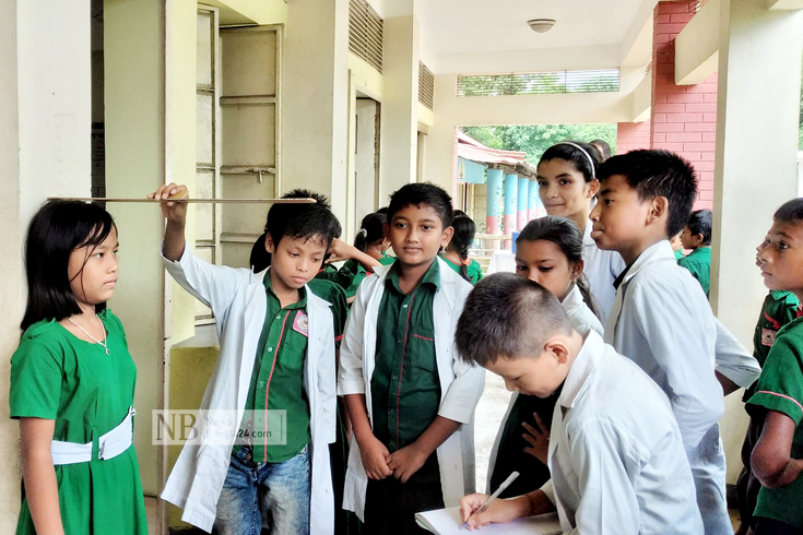 শিক্ষার্থীদের মধ্যে স্বাস্থ্য সচেতনতা বাড়াতে সারা দেশের প্রাথমিক বিদ্যালয়ে সপ্তাহব্যাপী খুুদে ডাক্তার কার্যক্রম শুরু হয়েছে। ক্ষুদে ডাক্তারদের কিছু স্বাস্থ্য শিক্ষা,পরিষ্কার-পরিচ্ছন্নতা ও সচেতনতা বিষয়ে ধারণা দেওয়া হয়। এরপর তারা তাদের সহপাঠি ও ছোটদের সাথে সেসব বিষয়ে আলোচনা করে। ক্ষুদে ডাক্তাররা নিজেরা সচেতন হবে এবং অন্যদের সচেতন করবে। মৌলভীবাজারের কমলগঞ্জ উপজেলার মঙ্গলপুর সরকারি প্রাথমিক বিদ্যালয়ে বৃহস্পতিবার দেখা মিললো এমন একদল ক্ষুদে ডাক্তারের। ছবি: সালাহ্উদ্দিন শুভ/নিউজবাংলা 
