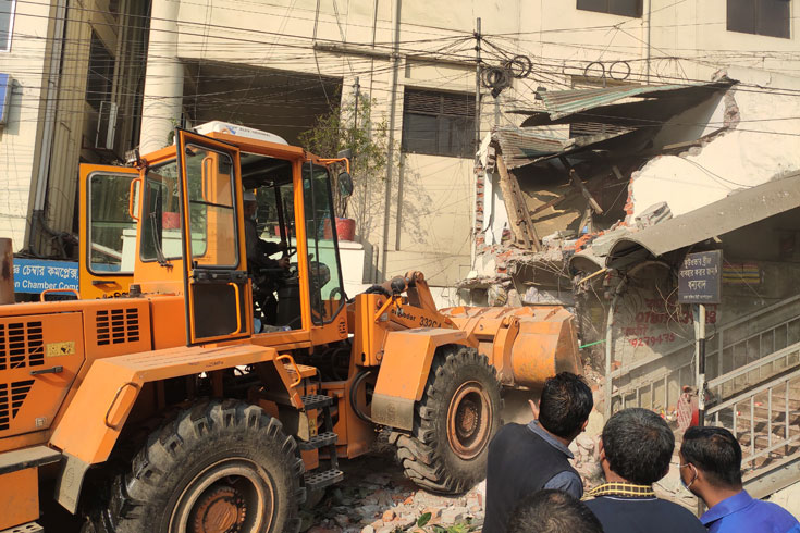 রাজধানীর শাহবাগ মোড়ে সড়কের পাশের বিভিন্ন অবৈধ স্থাপনা বৃহস্পতিবার দুপুরে উচ্ছেদ করে দক্ষিণ সিটি করপোরেশন। ছবি: সাইফুল ইসলাম  