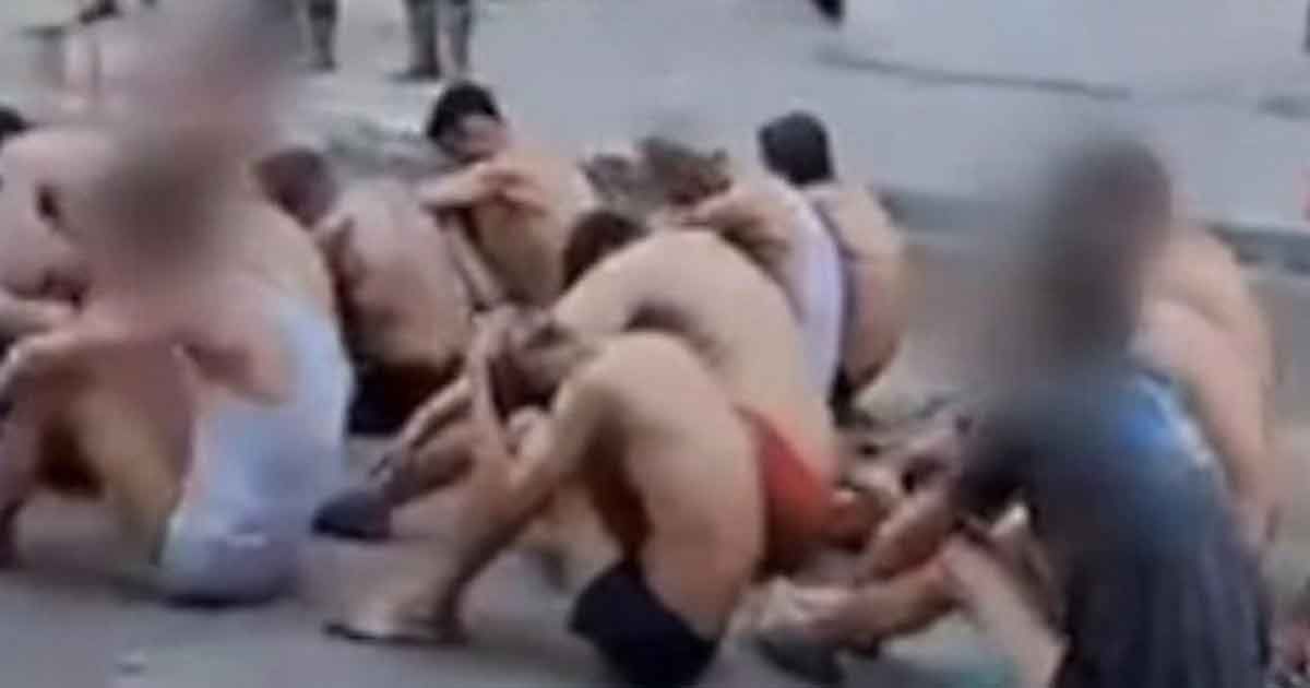 A-few-men-kneeling-in-their-underwear-are-guarded-by-Israeli-soldiers